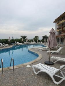 a large swimming pool with lounge chairs and an umbrella at Studio Apartment C32 in Dream Holiday Complex Ravda in Ravda