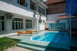 a swimming pool with two benches next to a building at Art Hostel in Tashkent