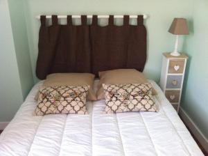 a bed with two pillows and a headboard in a bedroom at Petite escale Vivonnoise in Vivonne