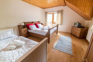 1 dormitorio con 2 camas y ventana en Holiday home Skalka, en Mýto pod Ďumbierom