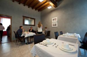 un grupo de personas sentadas en mesas en un restaurante en Albergo Morandi, en Reggio Emilia