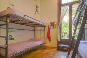 a bedroom with two bunk beds and a window at Milhouse Hostel Hipo in Buenos Aires