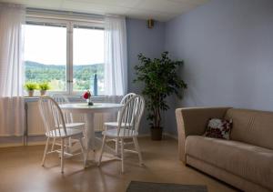 a living room with a table and chairs and a couch at Docksta Hotell in Docksta