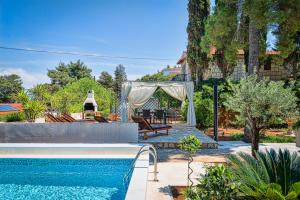 a backyard with a pool and a gazebo at Apartments Tamar in Jelsa