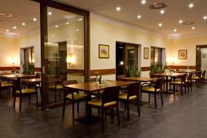 a dining room with wooden tables and chairs at Hotel Hermes in Krnov