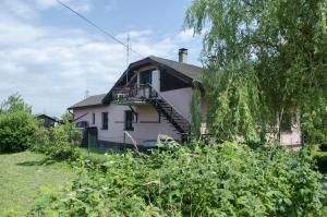 ein weißes Haus mit einem Balkon und einem Baum in der Unterkunft Dagmar Zajacová in Albrechtice