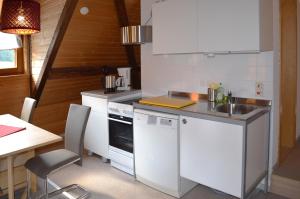 a kitchen with a counter and a sink and a table at Ferienwohnungen Sternenthal in Menzenschwand