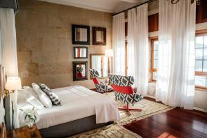 a bedroom with a bed and two chairs in it at Parador de Baiona in Baiona