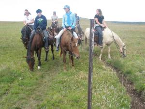 a group of people riding horses in a field at Sani Stone Lodge in Mokhotlong