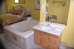a bathroom with a tub and a sink and a bed at River Lodge South in Pigeon Forge +28 photos