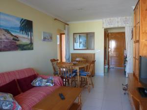 uma sala de estar com um sofá e uma mesa em Apartamento En Daimus Con Vistas Al Mar em Daimuz