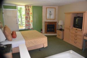 a bedroom with a bed and a television and a fireplace at River Lodge South in Pigeon Forge