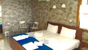 una camera da letto con un letto e due sedie di Kostis Rooms a Korissía