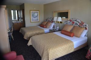 a hotel room with two beds and a mirror at River Lodge South in Pigeon Forge