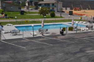 a pool with chairs and umbrellas in a parking lot at River Lodge South in Pigeon Forge