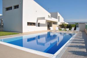 a villa with a swimming pool in front of a house at Ville Edilia Vacanze in Marina di Ragusa