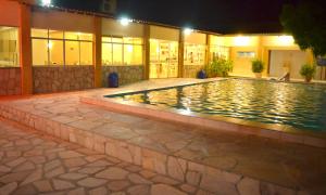 a swimming pool in front of a building at night at Hotel Brotas in Afogados da Ingàzeira