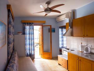a kitchen with a ceiling fan and an open door at Pension Dimitris in Votsi