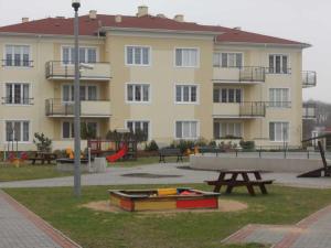 a large building with a picnic table and a playground at Apartament Jula in Grzybowo