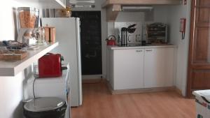 a kitchen with a white refrigerator and a red appliance at Casa Azul Hostel in Sintra