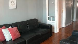 a black couch with two pillows on it in a living room at Casa Azul Hostel in Sintra