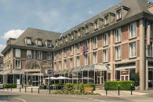 - un grand bâtiment en briques dans une rue de la ville dans l'établissement Mercure Abbeville Centre – Porte de La Baie de Somme, à Abbeville