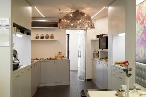 a kitchen with white cabinets and a large chandelier at Hotel Verlooy in Geel