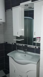 a bathroom with a white sink and a mirror at Apartments Royal Menex in Požarevac