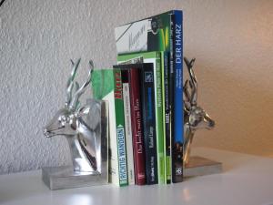 a shelf with books and a couple of deer statues at Apartment Harzgrün in Sankt Andreasberg