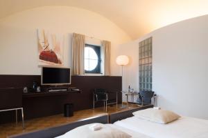 een hotelkamer met een bed en een televisie bij Hotel Verlooy in Geel