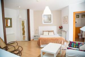 Un dormitorio con una cama y una sala de estar. en Casa Garrote, en Cuenca
