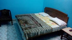 a bed in a bedroom with a blue wall at Vidya Guest House in Katra