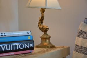 a lamp on a table next to a stack of books at The Dolphin Inn in Thorpeness