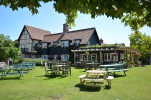 a group of tables and chairs in front of a building at The Dolphin Inn in Thorpeness
