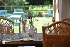 a wooden table with glasses and wine bottles on it at The Dolphin Inn in Thorpeness +26 photos