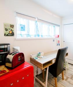Zimmer mit einem Schreibtisch und einem roten Koffer in der Unterkunft Guesthouse 77 in Eyrarbakki