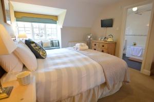 a bedroom with a large bed and a bathroom at The Dolphin Inn in Thorpeness
