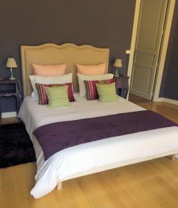 GUESTHOUSE La VILLAE في مازامي: غرفة نوم مع سرير أبيض كبير مع وسائد ملونة