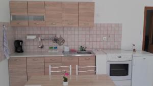a kitchen with wooden cabinets and white appliances at Apartman Lana in Banjole +13 photos