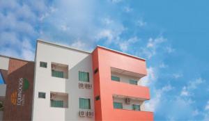 a red and white building with a sky in the background at Hotel Equinocios Essential in Barcarena