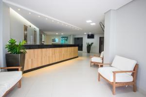 a lobby with chairs and a reception desk at Hotel Equinocios Essential in Barcarena