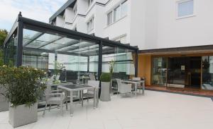 eine Terrasse mit Tischen und Stühlen außerhalb eines Gebäudes in der Unterkunft Hotel Grille in Erlangen