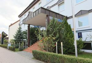 a building with stairs and plants in front of it at Hotel Grille in Erlangen