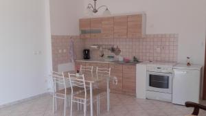 a kitchen with a table and chairs and a stove at Apartman Lana in Banjole