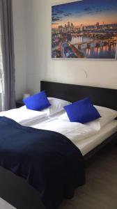 a bedroom with two beds with blue pillows at Main Hotel Frankfurt City in Frankfurt