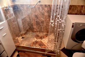 a bathroom with a shower with a shower curtain at Apartamento Romantico by the Ocean in Caniço +29 photos
