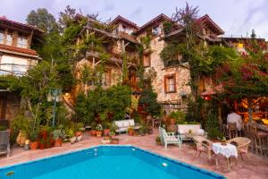 a house with a swimming pool in front of it at Fidanka Hotel in Kalkan