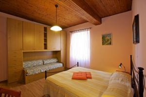 マッカーニョ・スペリオーレにあるVa Pensieroのベッドルーム1室(ベッド1台、ベンチ付)