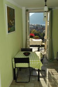 Zimmer mit einem Tisch und Stühlen sowie einem Balkon in der Unterkunft Appartamento del Sole in Maccagno Superiore