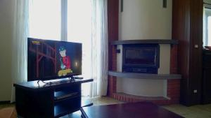 sala de estar con TV y chimenea en Casa Mariarosa, en Maccagno Inferiore